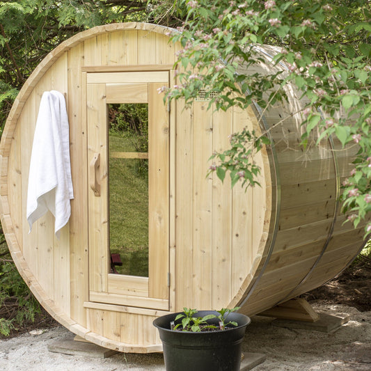 Canadian Timber Harmony 4-person white cedar barrel sauna, installed in a garden setting