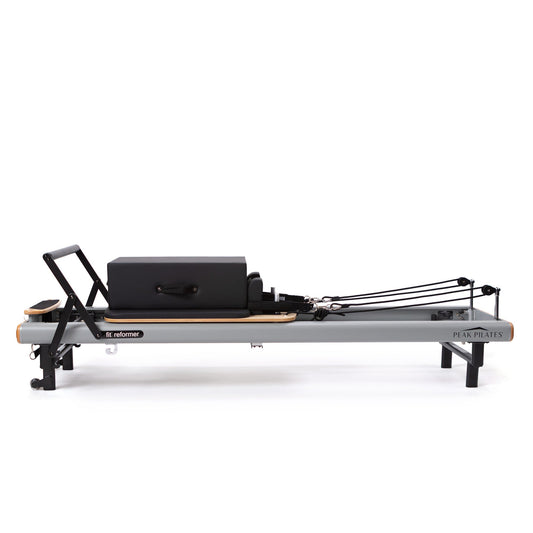 Peak Pilates fit Reformer with Long/Short Box, clean side profile on white background showing the grey frame and wood accents