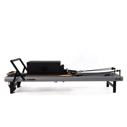Peak Pilates casa Reformer with Long/Short Box on white background, side view showing footbar, carriage and shoulder rests