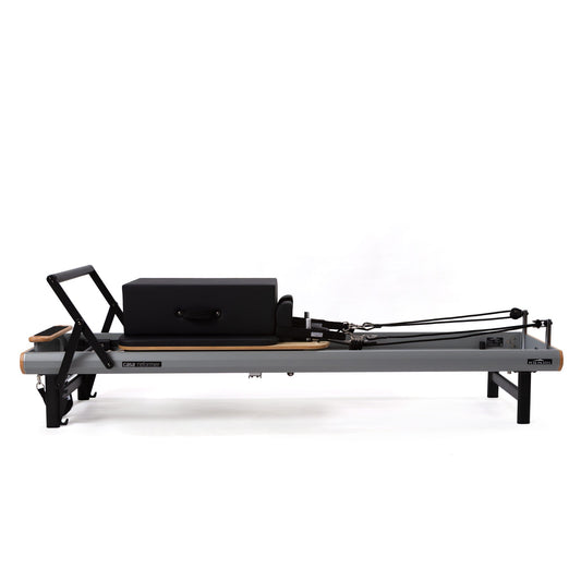 Peak Pilates casa Reformer with Long/Short Box on white background, side view showing footbar, carriage and shoulder rests