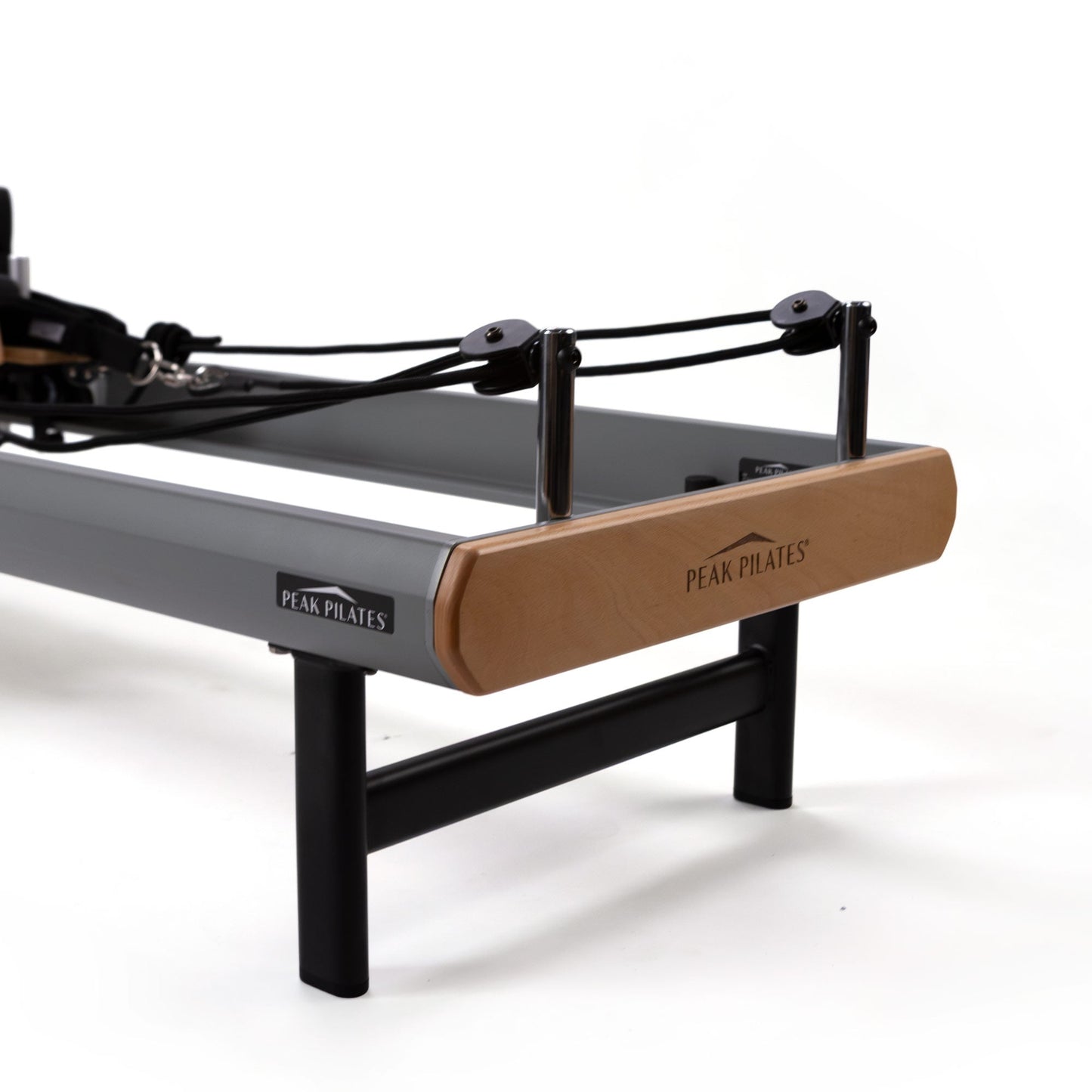 Peak Pilates casa Reformer with Long/Short Box, close-up detail of the wood-and-aluminum end panel and carriage construction