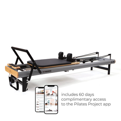 Peak Pilates casa Reformer with Long/Short Box, full side view with phone showing free Pilates Project app access